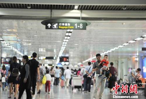 资料图 图为海口美兰机场到达大厅迎来大量进港旅客。 楚洪雨 摄